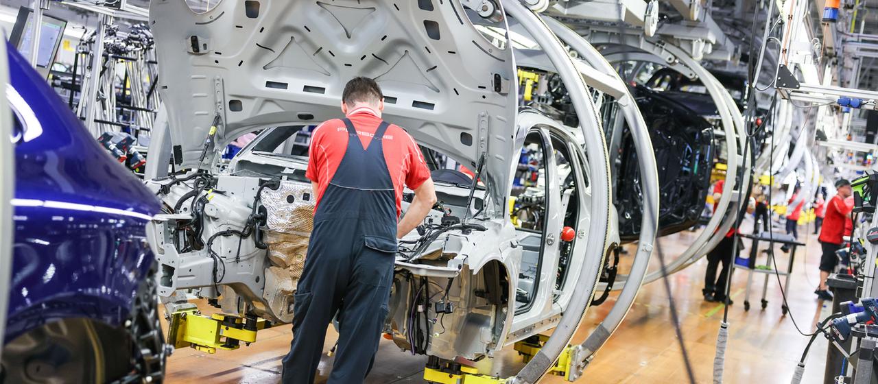 Des gens travaillent dans une usine appartenant au constructeur automobile Porsche.