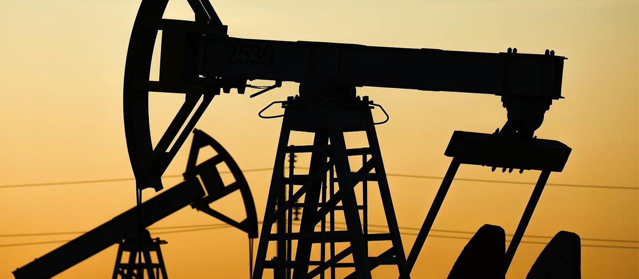 Silhouettes de pompes à huile à la lumière d'un coucher de soleil.