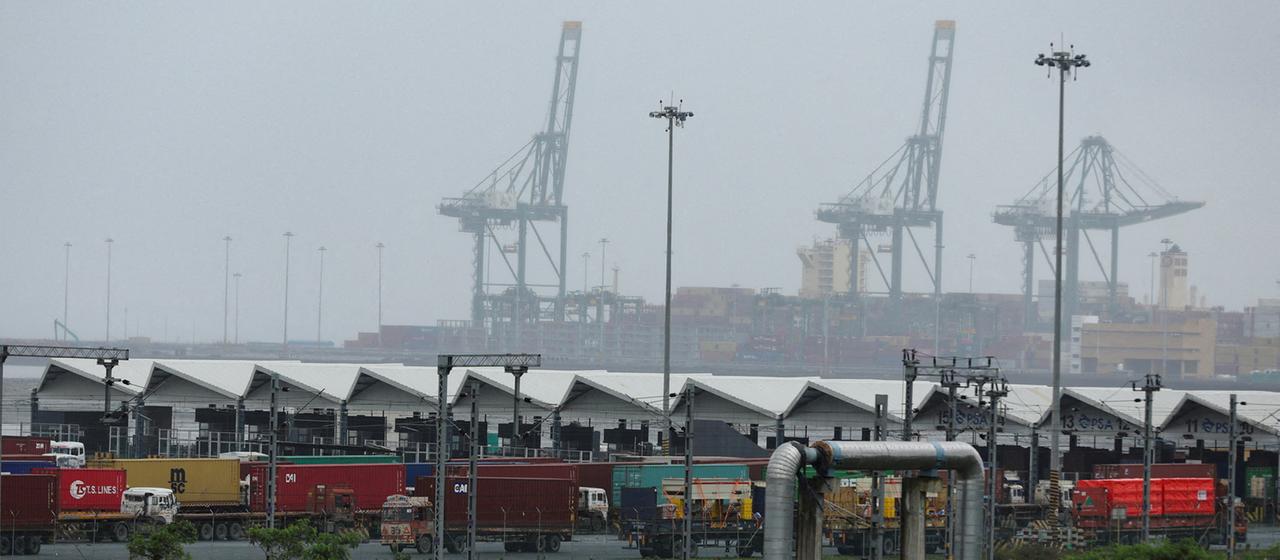 Trucks with shipping containers stand at the Jawaharlal Nehru Port in Navi Mumbai, India. 