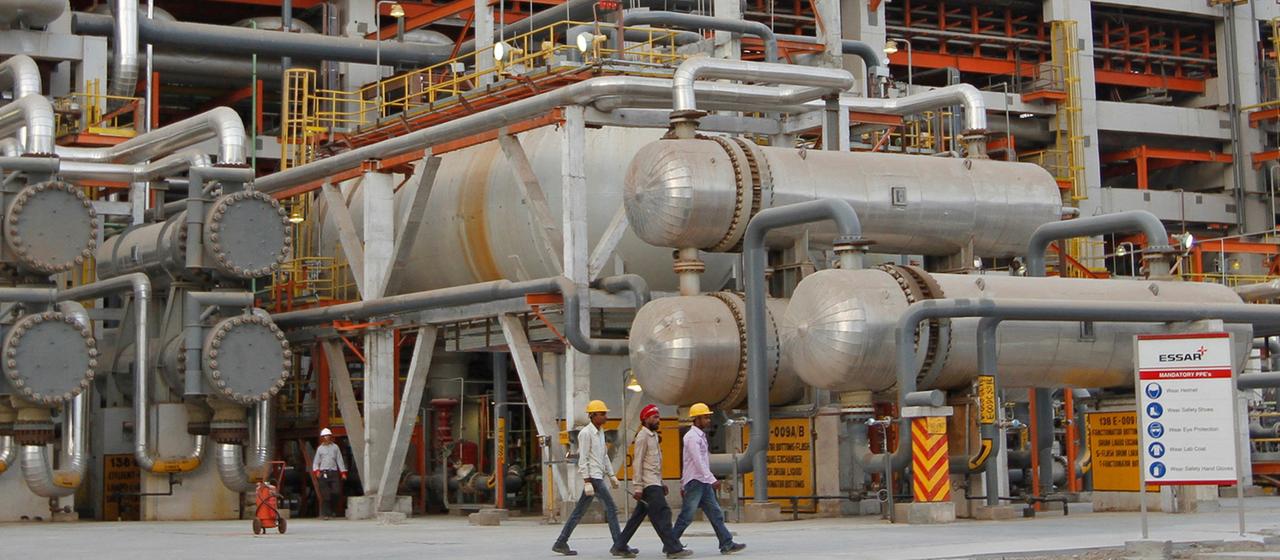 Des employés passent devant des canalisations de la raffinerie de Vadinar en Inde (photo d'archive de 2012).