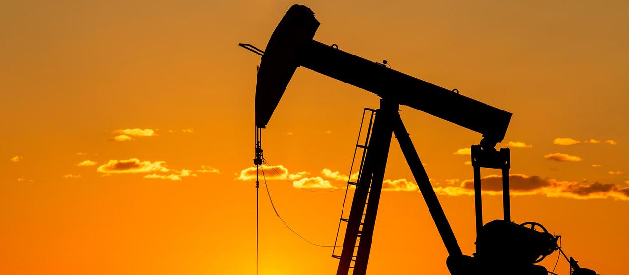 Silhouette d'une pompe à huile dans un champ pétrolifère.