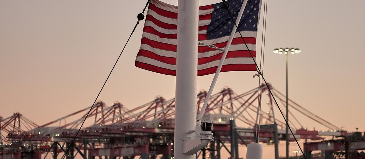 Un drapeau américain flotte devant le terminal à conteneurs de Long Beach (LBCT), dans le port de Long Beach, en Californie.