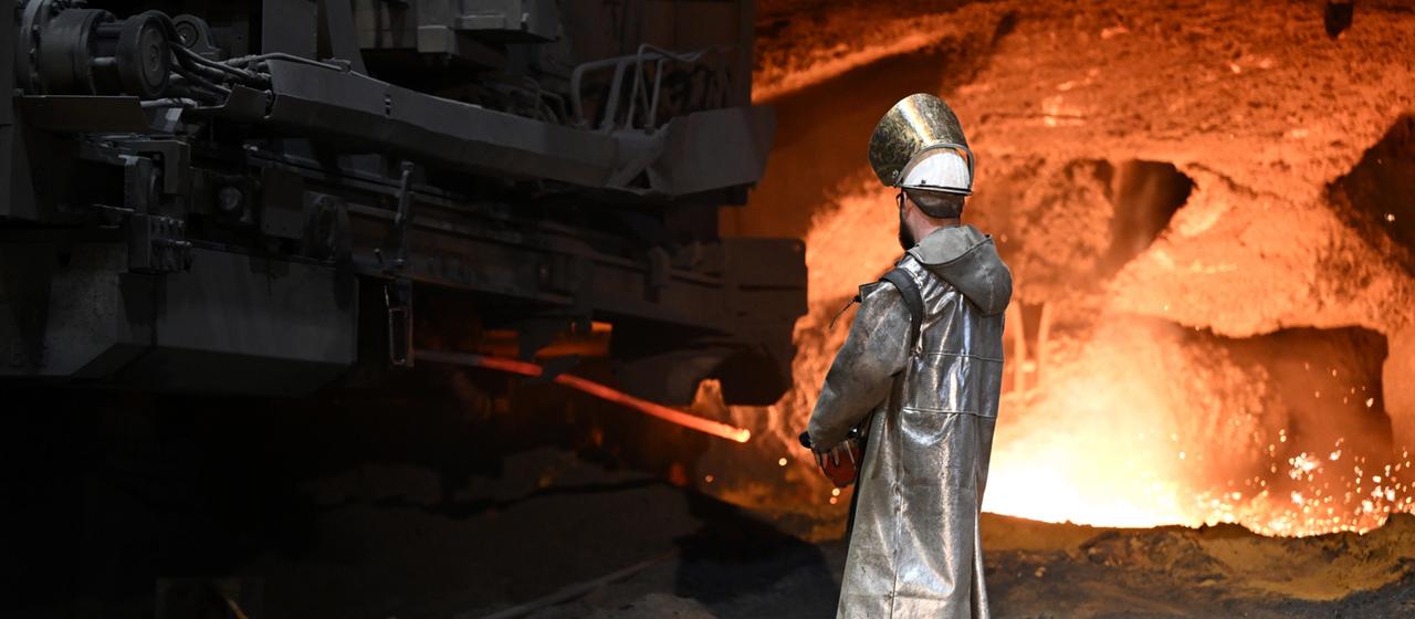 Un sidérurgiste se tient devant un haut fourneau de Thyssenkrupp Steel à Duisburg (archives décembre 2024)