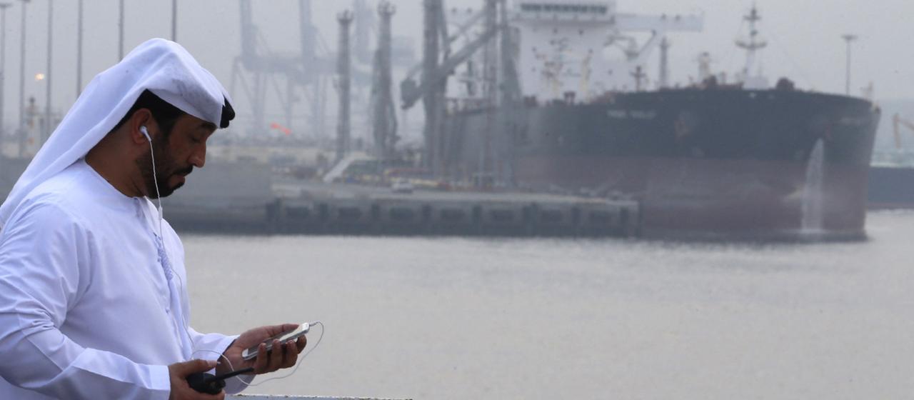 Un homme se tient devant le port pétrolier de Fujairah.